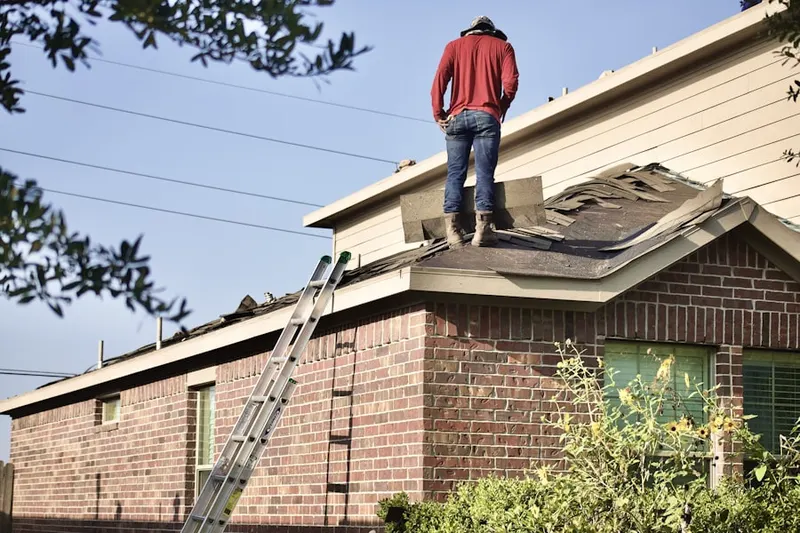 Professional roofer working on a residential roof in Stittville